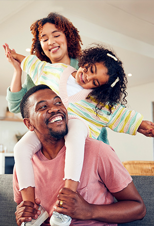 Famille de deux parents enlaçant leur enfant
