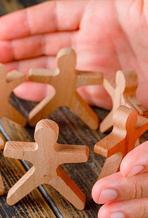 mains entourant des figurines en cercle